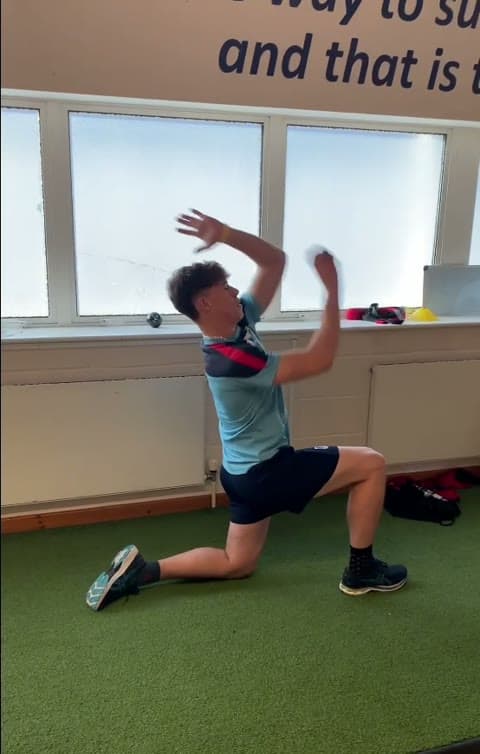 A bowler doing kneeling weighted-ball throws