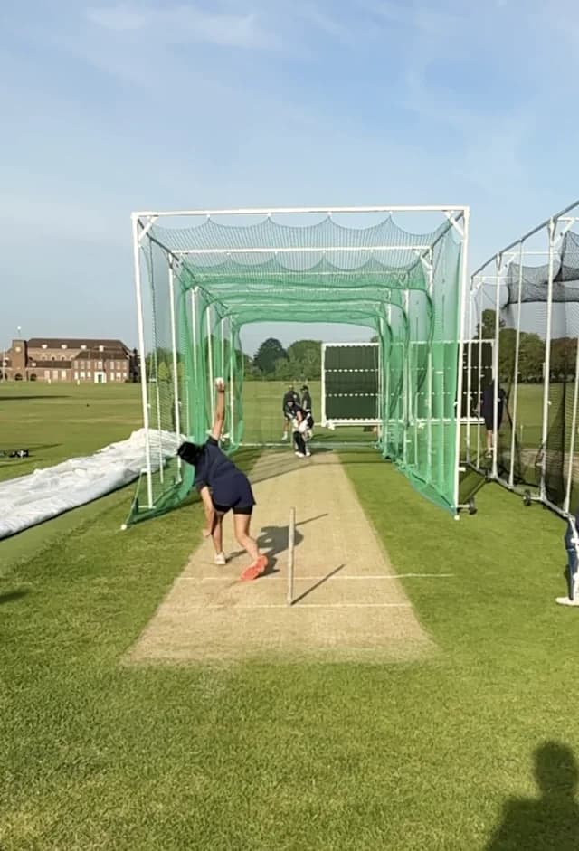 A bowler filmed from directly behind, phone in portrait